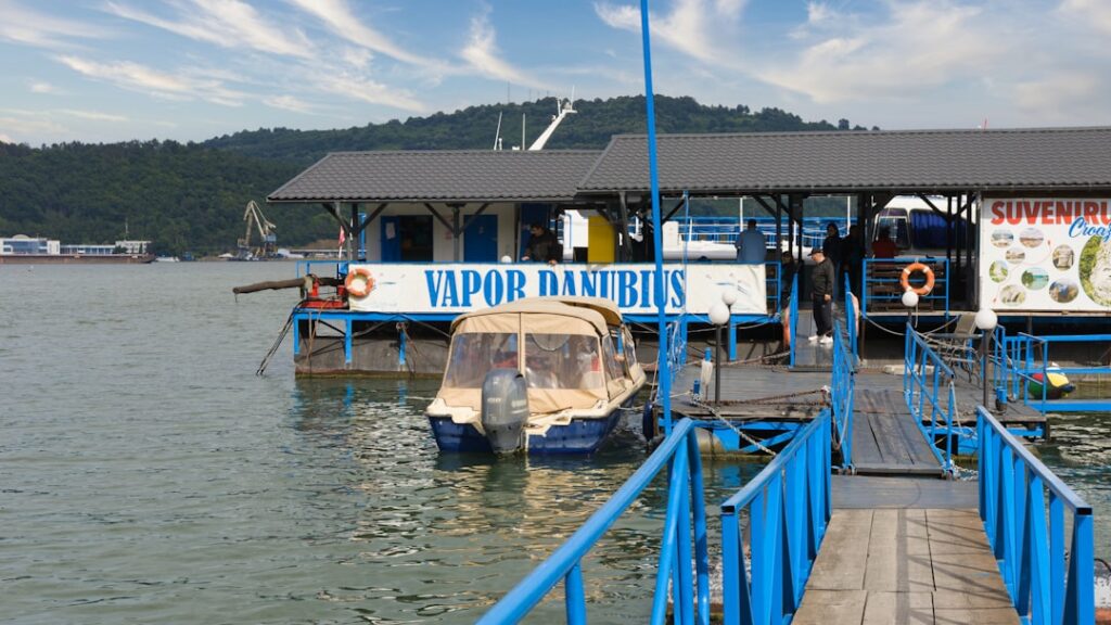 A boat docked at a pier with people standing on it